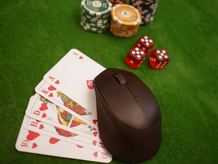 card games, dice, chips, and a computer mouse on the gaming table