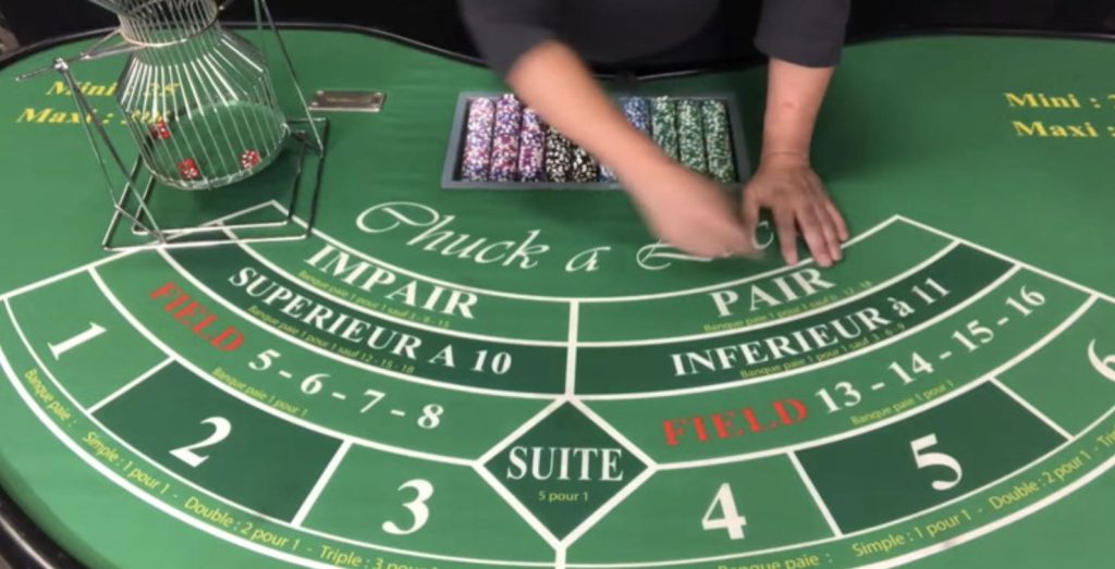 A live dealer preparing the table for a Chuck-A-Luck round