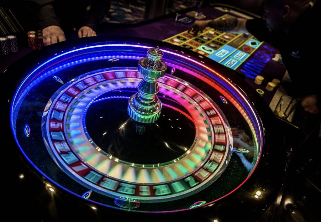 A photo of a neon Roulette wheel in a land-based casino