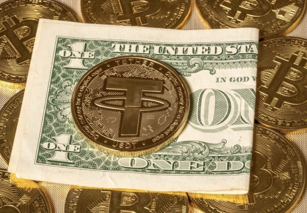 A Tether crypto coin lying on a dollar bill